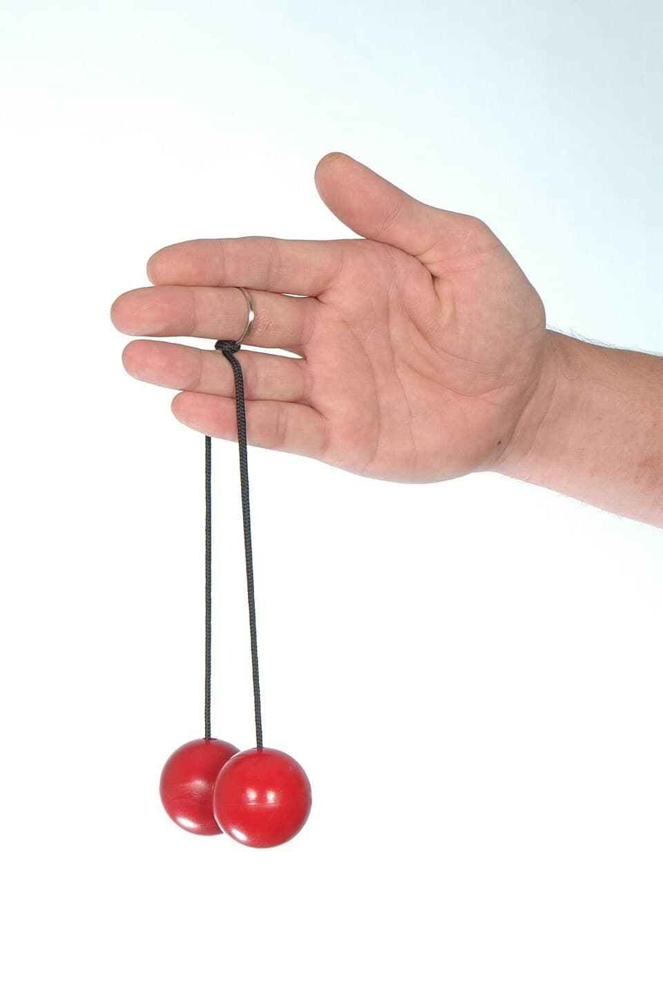 Clackers toy being held between the fingers