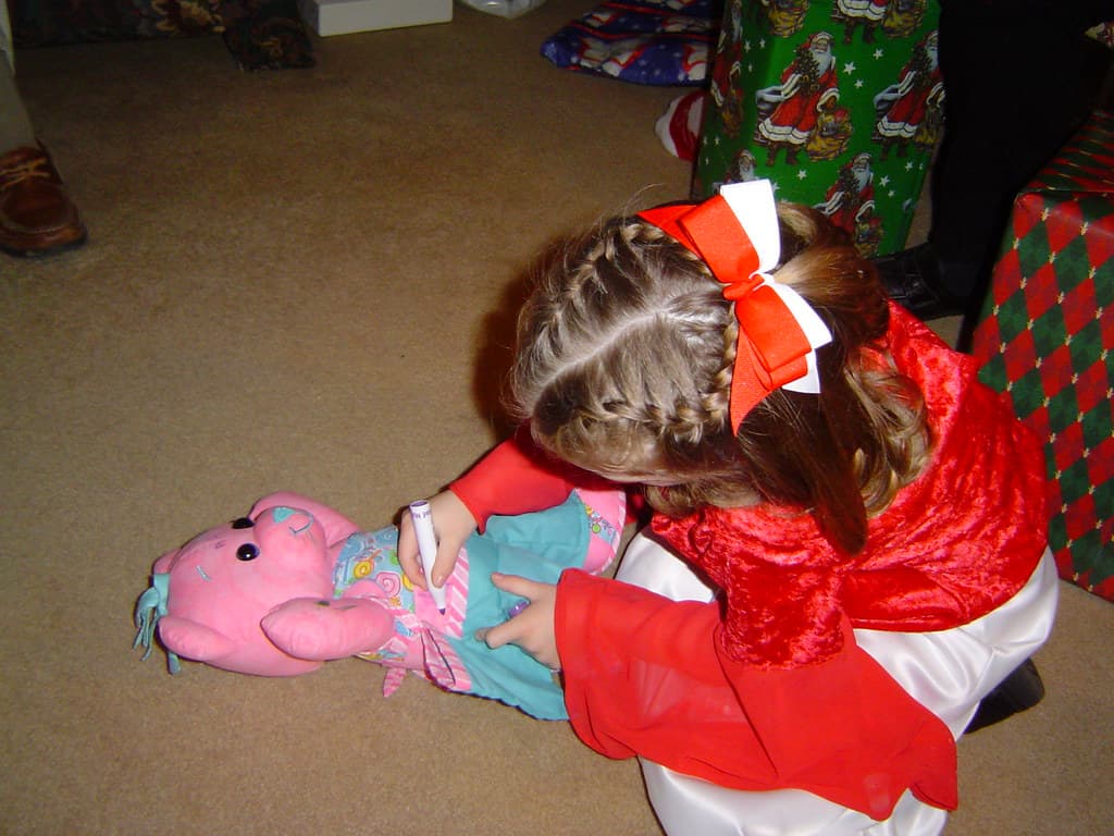 Child drawing on a Doodle Bear plush toy
