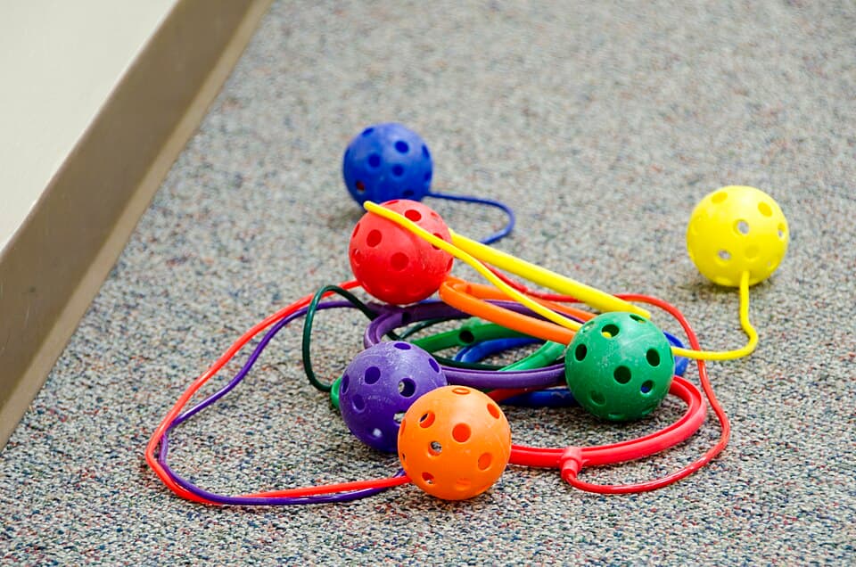 Skip-It toy with colorful balls and strings on carpet
