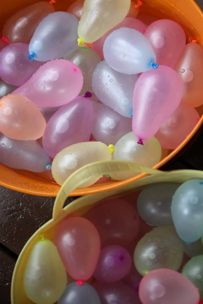 Bucket full of colorful filled water balloons