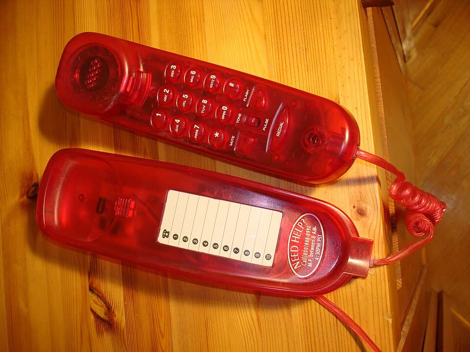 a transparent red landline telephone.