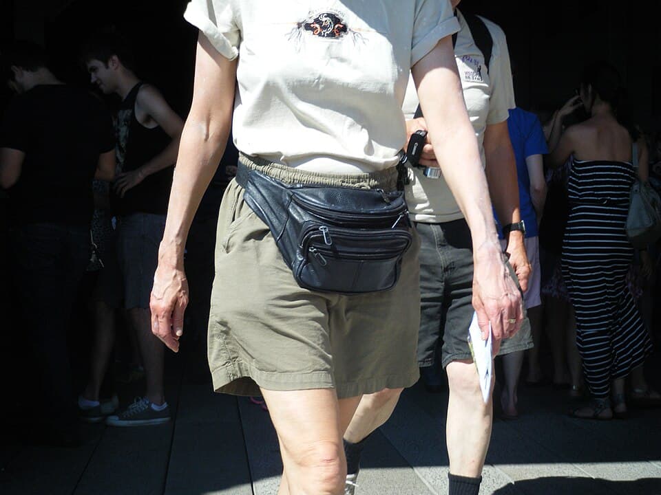 Person wearing a black leather fanny pack